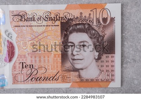 Currency of Great Britain (England) pound. Banknotes with denomination and 10 images of Queen Elizabeth portrait on a gray background