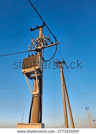 Current transformer and high voltage power lines on blue background