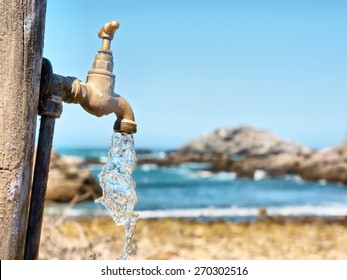 Current Water Flowing From Tap Against Rocky Beach. Shot In South Africa. 