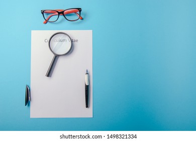 Curriculum Vitae Written On An Blank White Paper On Blue Background