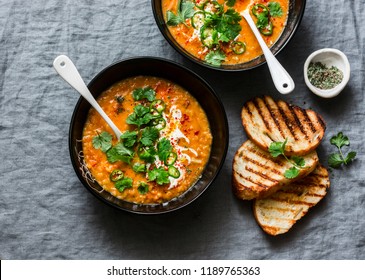 Curried red lentil tomato and coconut soup - delicious vegetarian food on grey background, top view. Flat lay served healthy lunch     