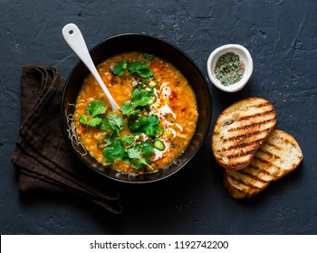 Curried Red Lentil Tomato And Coconut Soup - Delicious Vegetarian Food On Dark Background, Top View    