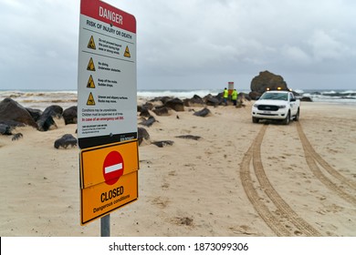 Currumbin, Gold Coast Australia, December 13 2020 Council workers putting up Beach warning signs as heavy rain, wind and large swells close down beaches at the popular surf spot Currumbin Rocks. 
