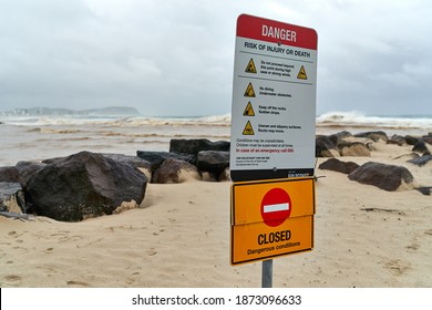 Currumbin, QLD, Australia, December 13 2020: Danger Beach Closed Sign warning people during heavy rain and big ocean swells at popular surf spot Currumbin Rocks Gold Coast Australia