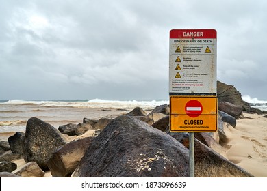 Currumbin, QLD, Australia, December 13 2020: Danger Beach Closed Sign warning people during heavy rain and big ocean swells at popular surf spot Currumbin Rocks Gold Coast Australia