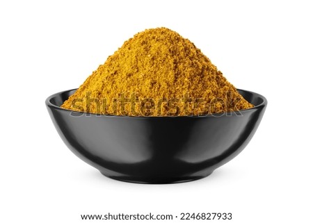 Curry powder in round black bowl isolated on white background. Front view.