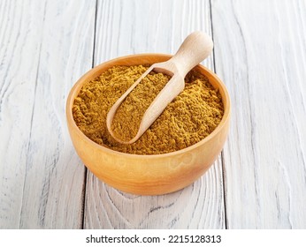 Curry Powder In Wooden Bowl On White Wooden Background