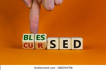 Cursed or blessed. Male hand flips a wooden cube and changes a word 'cursed' to 'blessed' or vice versa. Beautiful orange background, copy space. Religious and cursed or blessed concept. - Shutterstock ID 1882954708
