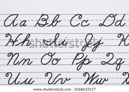 Cursive handwriting practice sheet showing the alphabet written on lined paper for educational purposes. Ideal for learning and teaching writing.