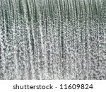 a curtain of water falling over a dam