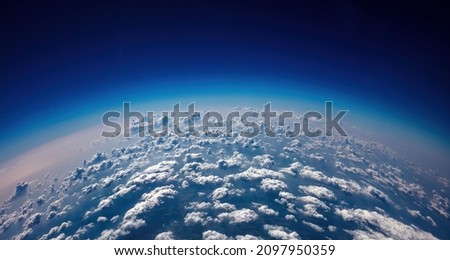 Curvature of planet earth. Aerial shot. Blue cloudy sky over land. Space, science concept
