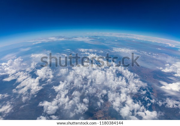 Curvature of planet earth. Aerial shot. Blue sky and\
clouds over land