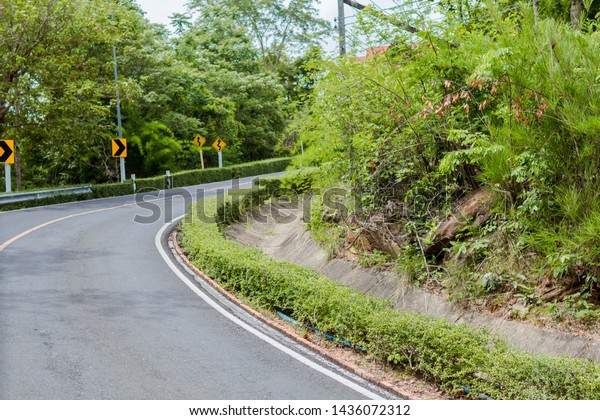 Curve in the forest,\
Bend street up to the mountain, Traffic warning sign label for show\
that the road curves 