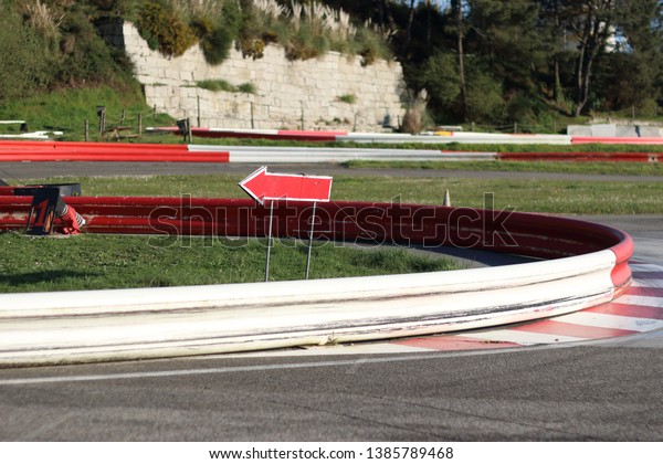 curve of a karts circuit with an arrow pointing\
the direction