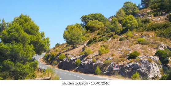 A Curve In The Massif Of La Clape, On The Road That Leads To Narbonne-Plage, In The South Of France, Passing Down Rocky Cliffs Covered With Dry Grass In An Arid, Mediterranean Shrubland Landscape