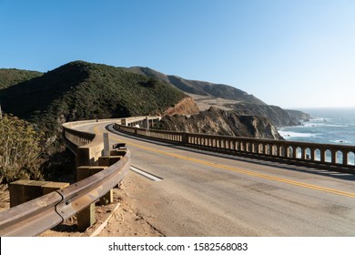 Curve In The Road At Big Sur's Bixby Creek Bridge Along The Pacific Coast Highway With Amazing Mountain Views And Ocean Seascapes.