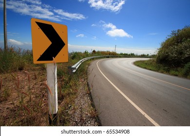 Curve Road Sign On Down Hill.