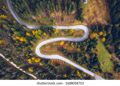 Curved Bending Road In The Forest. Aerial Image Of A Road. Forrest Pattern. Scenic Curvy Road Seen From A Drone In Autumn. Aerial Top Down View Of Zig Zag Winding Mountain Road, Drone Shot.