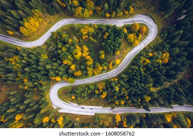 Curved Bending Road In The Forest. Aerial Image Of A Road. Forrest Pattern. Scenic Curvy Road Seen From A Drone In Autumn. Aerial Top Down View Of Zig Zag Winding Mountain Road, Drone Shot.