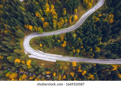 Curved Bending Road In The Forest. Aerial Image Of A Road. Forrest Pattern. Scenic Curvy Road Seen From A Drone In Autumn. Aerial Top Down View Of Zig Zag Winding Mountain Road, Drone Shot.