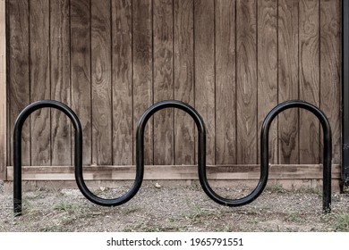 Curved Bike Rack In Front Of Wooden Wall