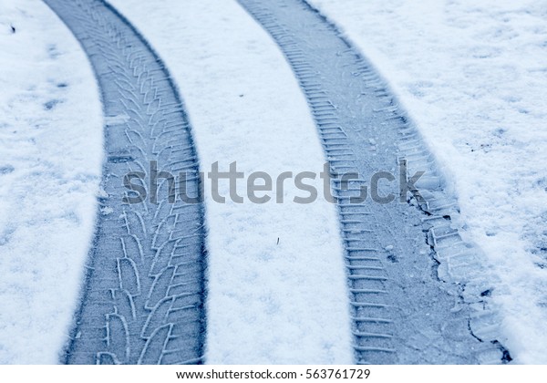 Curved car tracks in the\
snow closeup
