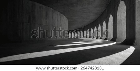 A curved concrete structure with arched openings allows sunlight to cast long shadows across the floor. The interior is dark and empty, emphasizing the archi...