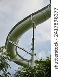 Curved Giant Water Slide with Green Foliage - Ground Up View