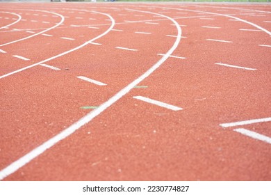 Curved lines and white dotted lines that contrast with the orange rubber floor. - Shutterstock ID 2230774827