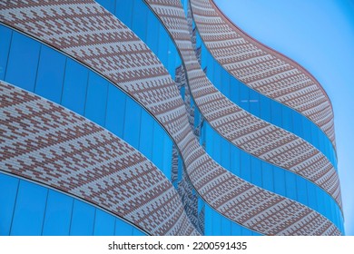 Curved modern building with bricks and reflective glass walls at downtown Tucson, Arizona. Low angle view of a modern building exterior against the blue sky background. - Powered by Shutterstock