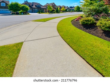Curved pedestrian sidewalk in a nice neighborhood in the suburbs of Vancouver, Canada.