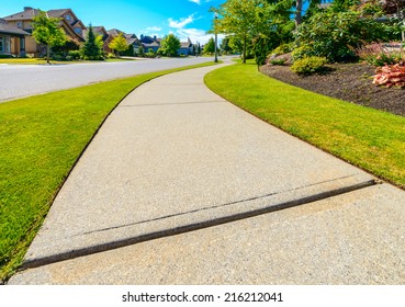 Curved pedestrian sidewalk in a nice neighborhood in the suburbs of Vancouver, Canada.