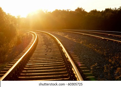 Curved railroad in sunset
