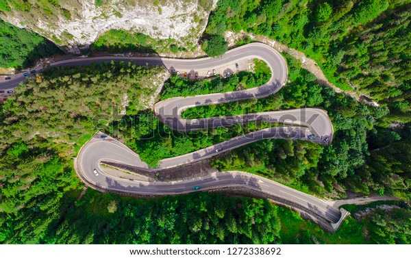 curved road with cars and\
beautiful forest landscape. Bicaz gorges, Romania. Aerial view from\
drone