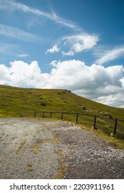 Curved Road In The Meadow With Cloudy Blue Sky - Landscape Photo. Vertical Image Of Rural Scene - Hills On Sunny Day.