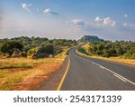 curved road in the nature, south africa landscape with rocky hill and bush trees