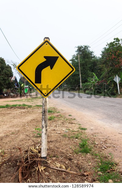 Curved Road\
Traffic Sign on the road at country\
side