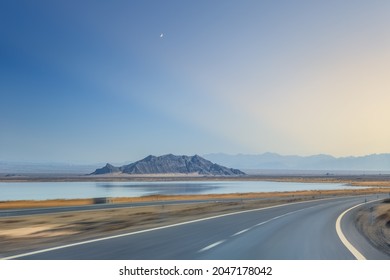 Curved Road In Western Landscape With Car Moving Motion Blur, Wilderness Highway Against A Dramatic Sky