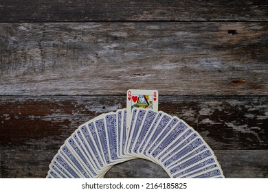 Curved row of old blue playing cards face down with Queen of Hea