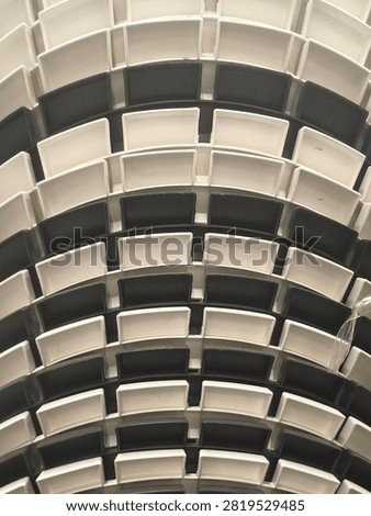 Curved rows of beige rectangular tiles arranged in a fan-like arch pattern. Modern architectural texture background with subtle shadows.