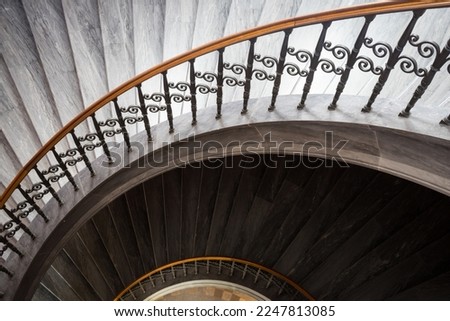 Curved stairs with marble steps and steel railing at the the luxury hall.
