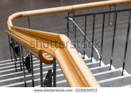 Curved wooden handrail close-up photo with selective soft focus, modern architecture
