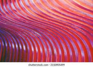 Curved wooden slats. Beautiful gradient from burgundy to crimson. Wood texture. Abstract background. Building facade element.