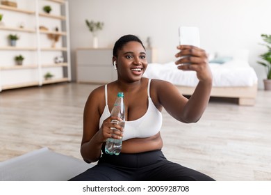 Curvy African American Woman Taking Selfie On Break From Home Workout, Talking To Personal Trainer On Web At Home. Overweight Black Lady With Smartphone Making Photo Of Herself On Domestic Training