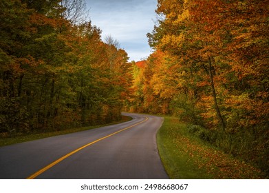 Curvy asphalt parkway road crossing the forest in Gatineau Park during fall rhapsody, colourful autumn foliage, Canadian landscape. Photo taken in Gatineau, Quebec, Canada in October 2022. - Powered by Shutterstock