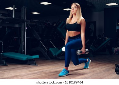 Curvy Fit Young Blonde Woman Lifting Dumbbell In A Gym