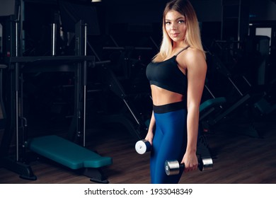 Curvy Fit Young Blonde Woman Lifting Dumbbell In A Gym