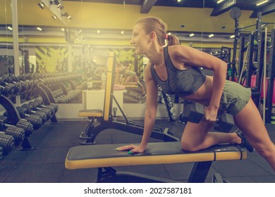 Curvy Fit Young Woman Lifting Dumbbell With One Arm In A Gym