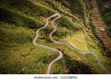 Curvy mountain road on the green part of Tenerife island, Spain. Top aerial view