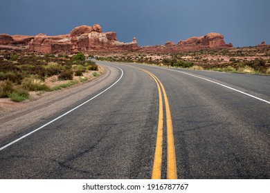 Curvy Road, Arches Scenic Drive, Rock Pinnacles Behind, Thunderclouds, Arches National Park, Utah, USA